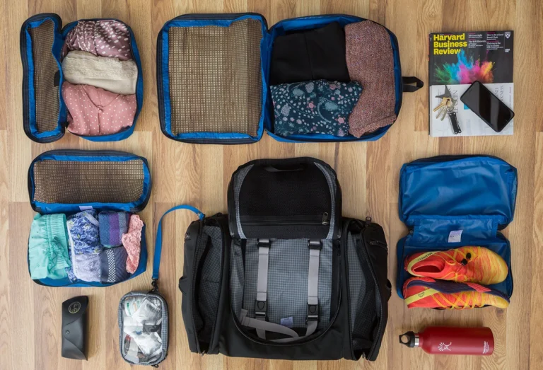 Blue and black travel organizers laid out with packed contents