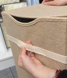 Close-up of reinforced handles with X-cross stitching on fabric storage bin