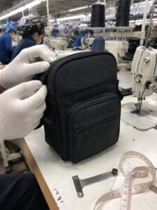 Gloved hands inspecting a black travel organizer
